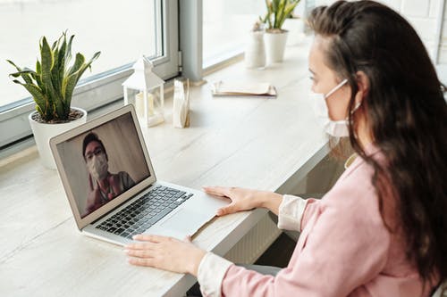 Woman videocalling while wearing facemask